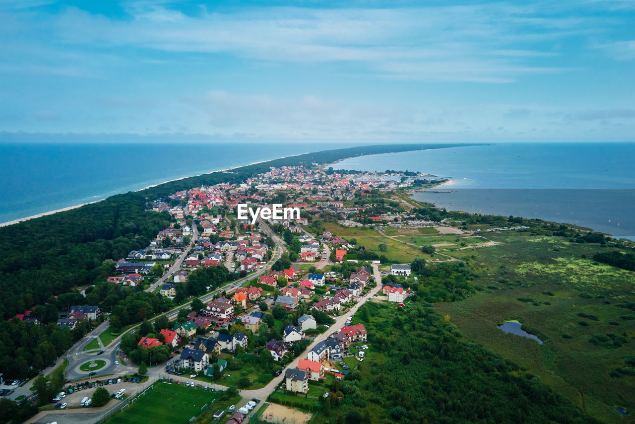 High angle view of townscape by sea against sky