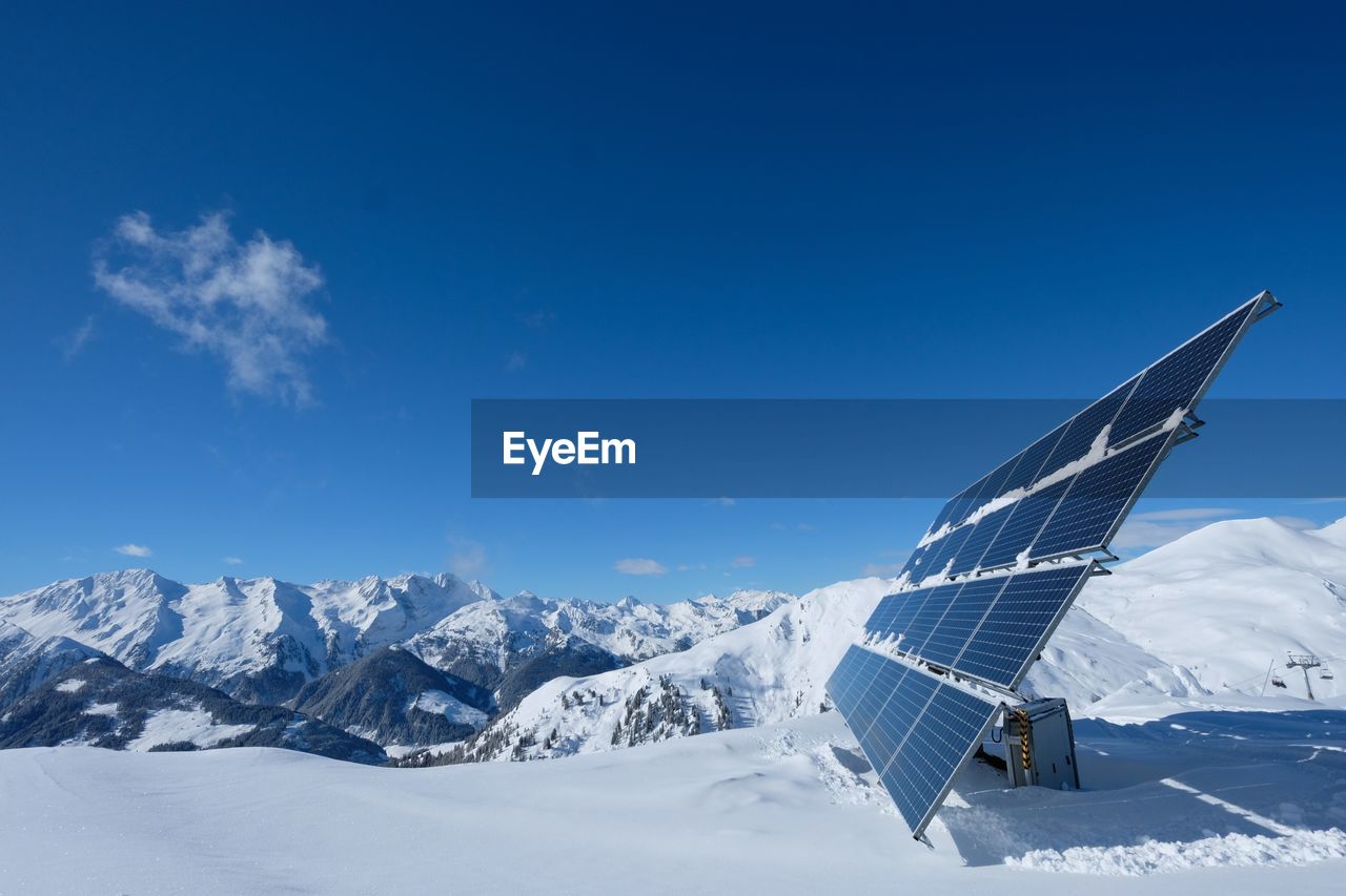 Solar panel on snow covered ground against sky