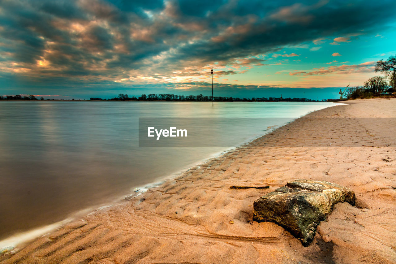 Scenic view of beach against sky during sunset