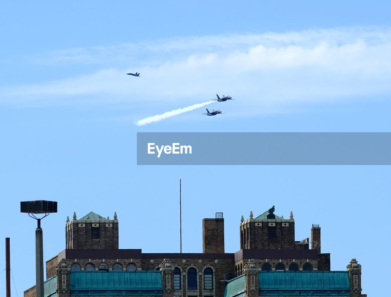 LOW ANGLE VIEW OF AIRPLANE FLYING IN BLUE SKY