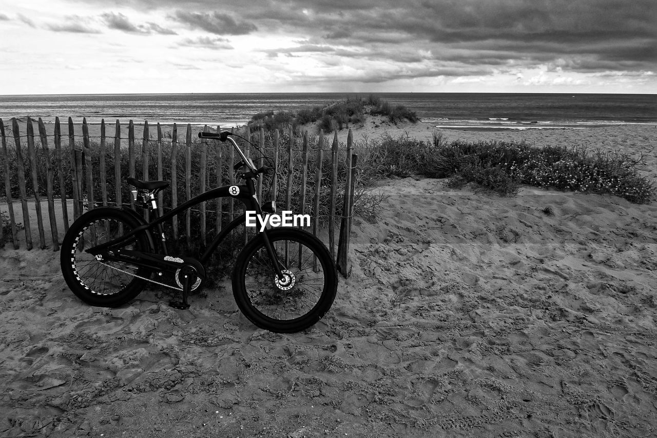 Bicycle on beach against sky