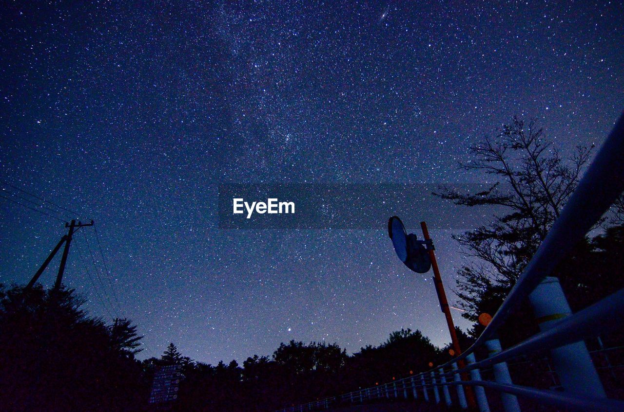 Low angle view of silhouette trees against star field at night