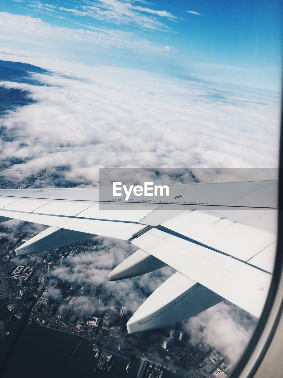 Low angle view of airplane wing over landscape