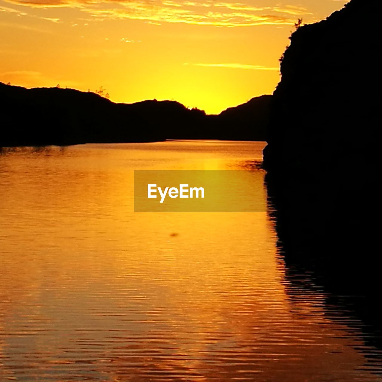 SCENIC VIEW OF LAKE AGAINST ORANGE SKY