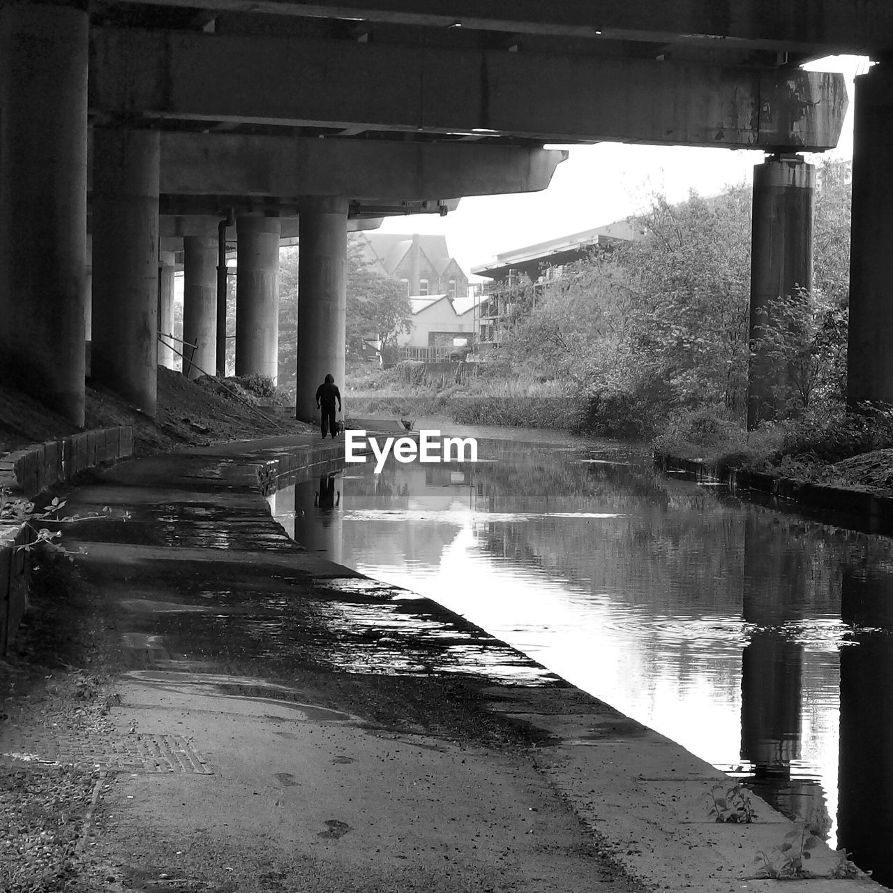 Distance shot of a person walking under bridge