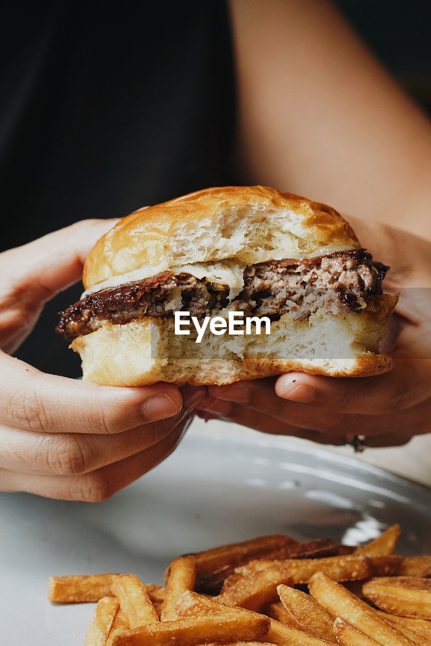 Close-up of hands holding burger