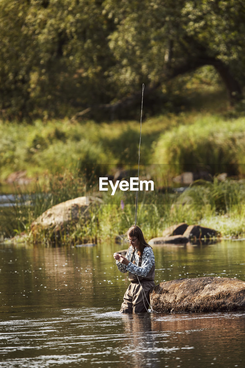 Woman fishing in lake