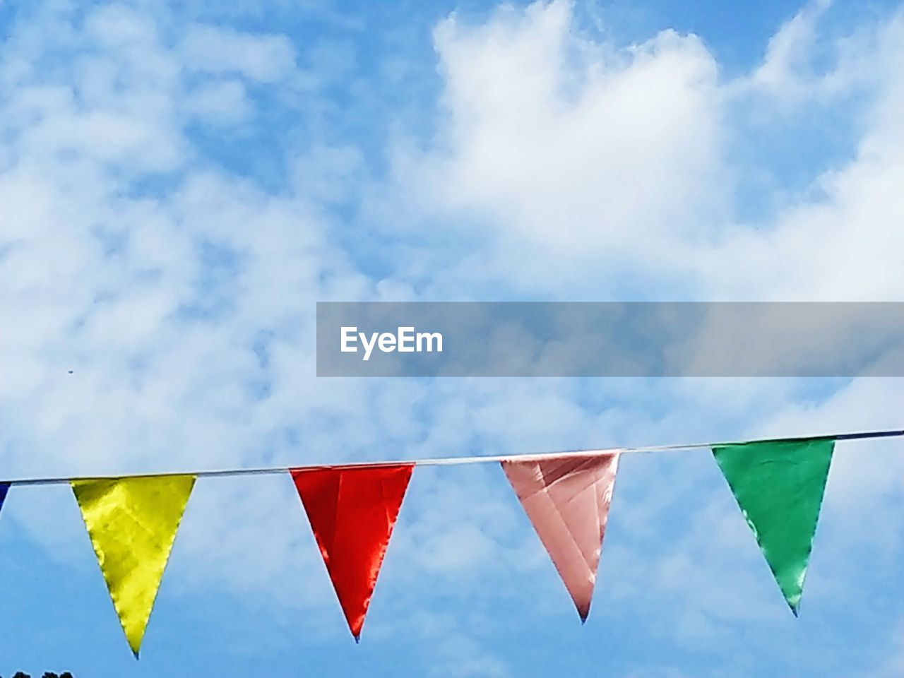 Low angle view of buntings hanging against sky