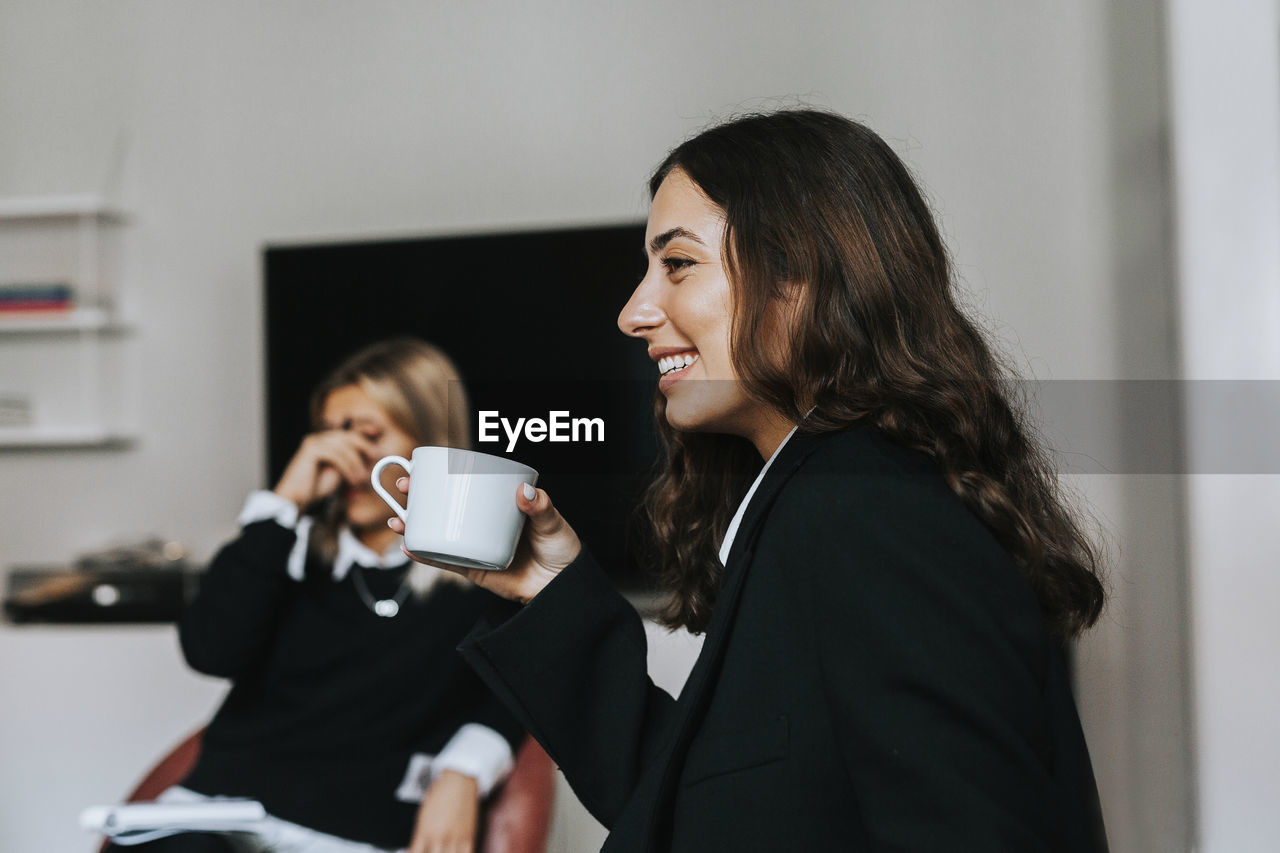 Smiling woman in office during coffee break