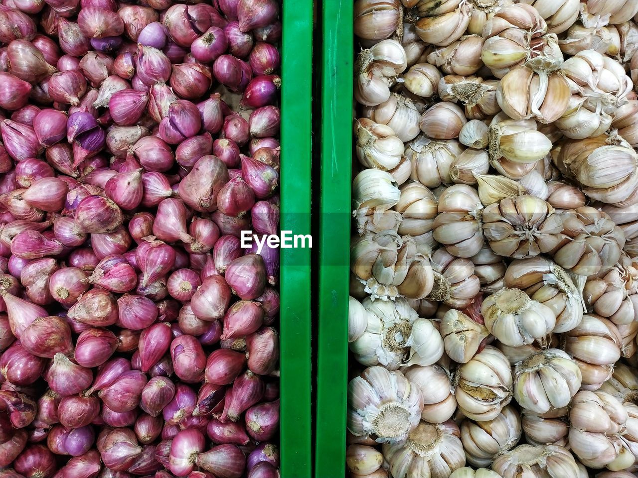 Fresh onions and garlics in each containers.