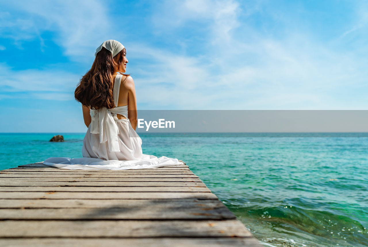 Rear view of woman in sea against sky