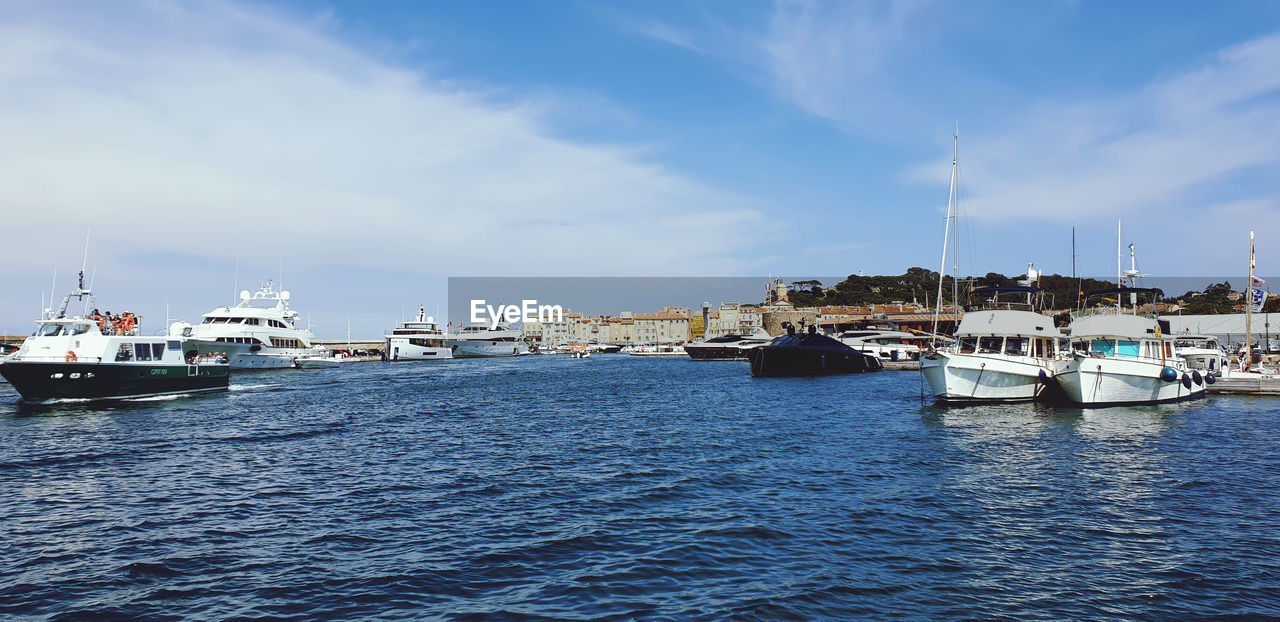 SAILBOATS MOORED IN HARBOR