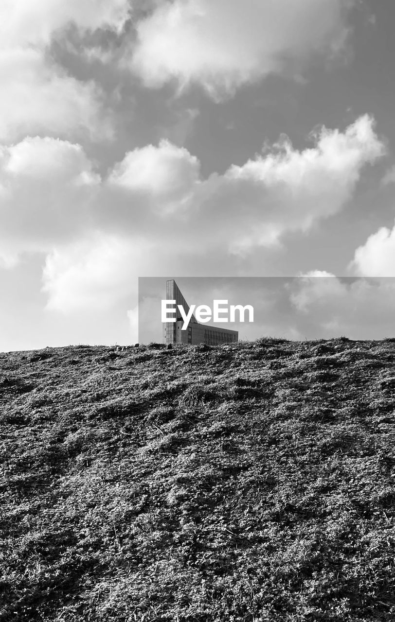 Low angle view of old building on field against sky