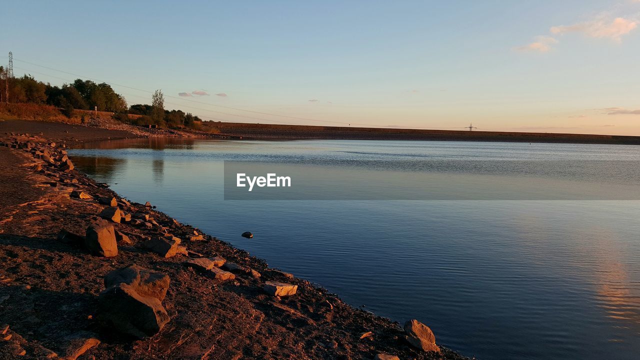 CALM LAKE AGAINST THE SKY