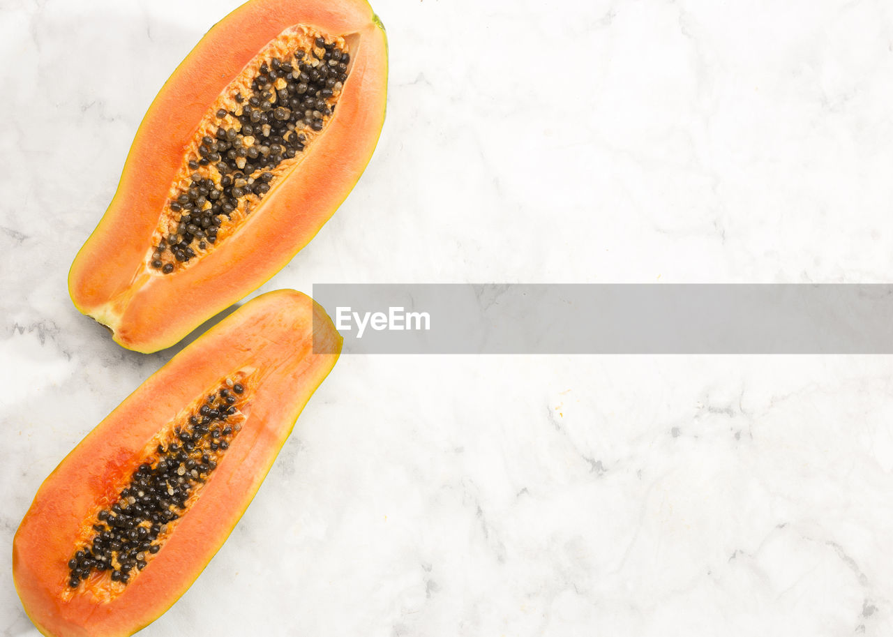 food and drink, food, plant, healthy eating, wellbeing, fruit, orange color, freshness, produce, seed, melon, no people, cross section, orange, high angle view, halved, indoors, studio shot, slice, tropical fruit