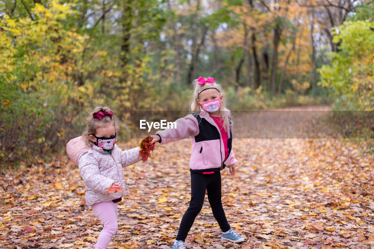 Full length of cute girls in park during autumn