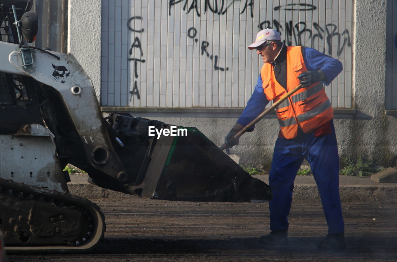 FULL LENGTH OF MAN WORKING ON MOTORCYCLE