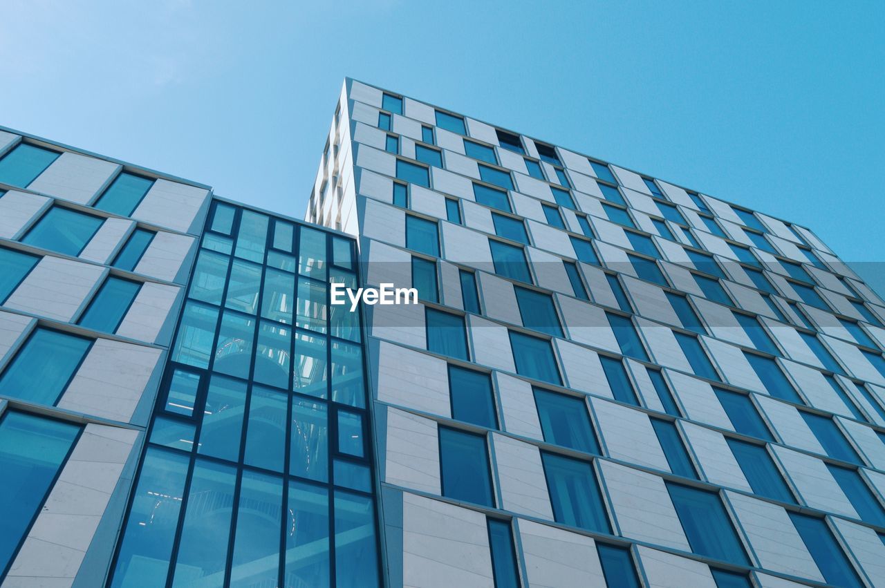 Low angle view of modern building against clear blue sky