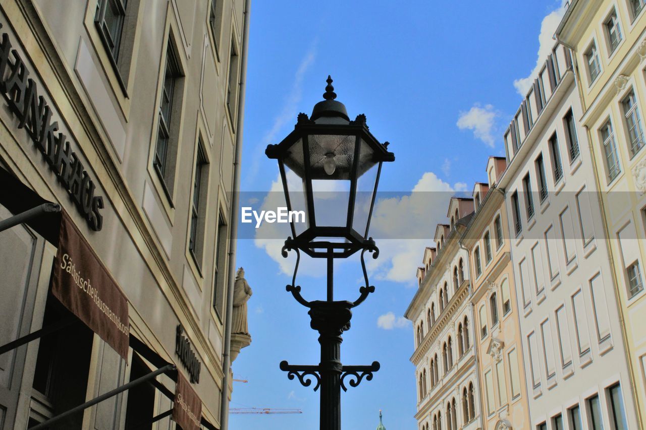 LOW ANGLE VIEW OF STREET LIGHT WITH BUILDINGS IN BACKGROUND