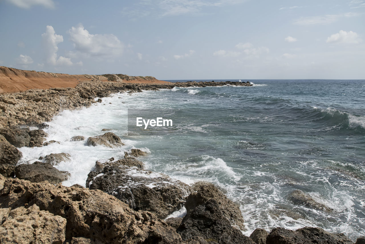 SCENIC VIEW OF ROCKS ON SHORE AGAINST SKY