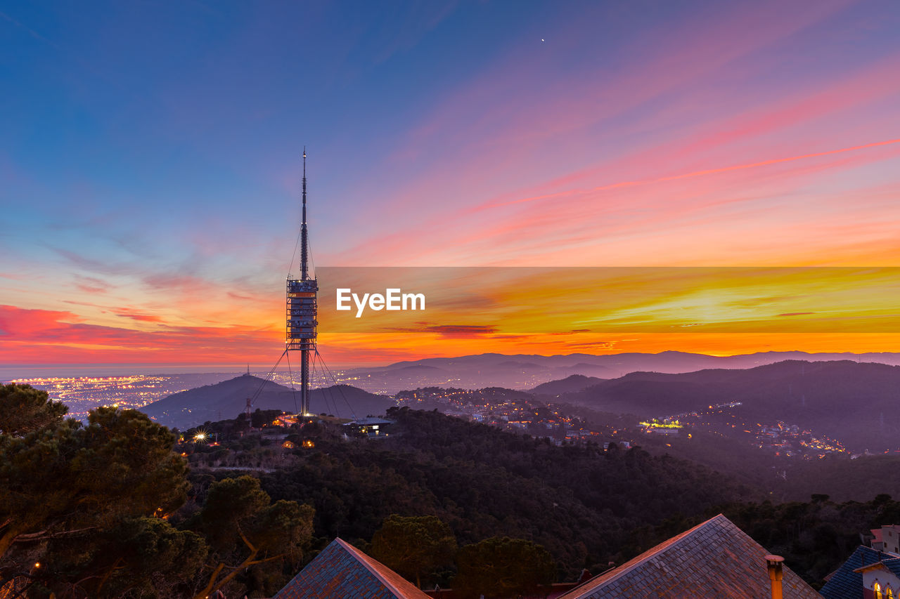 Sunset in barcelona, spain with the collserola tower in the background