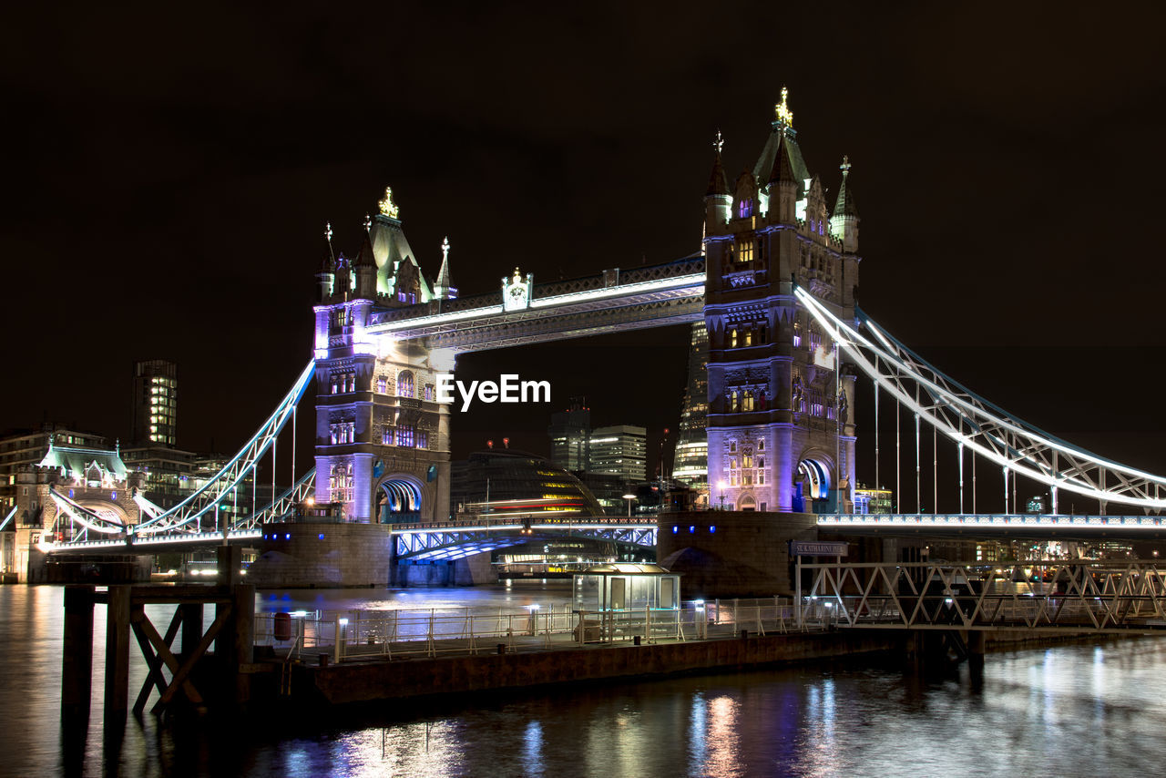 Illuminated tower bridge by river thames at night