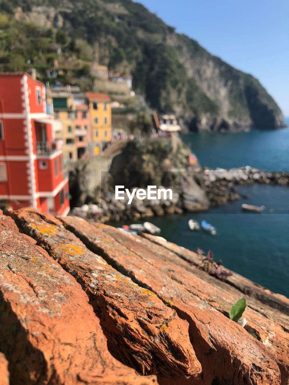 Rocks on beach by sea against mountain