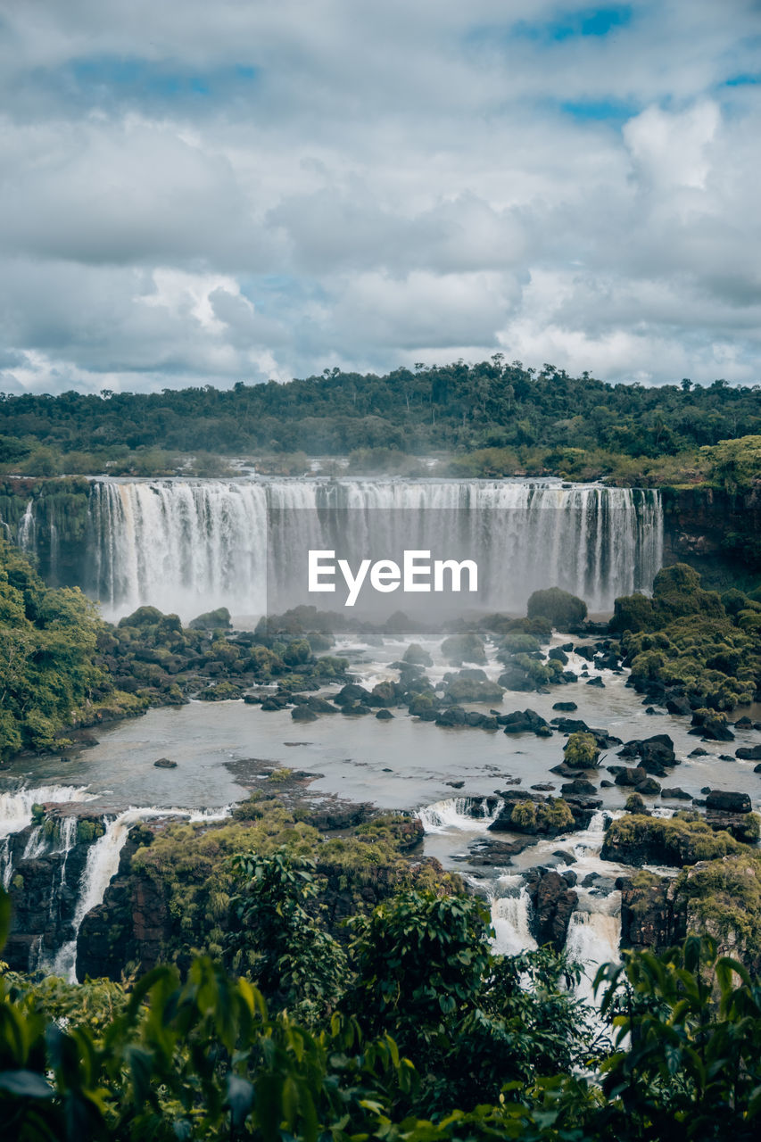 Scenic view of waterfall against sky