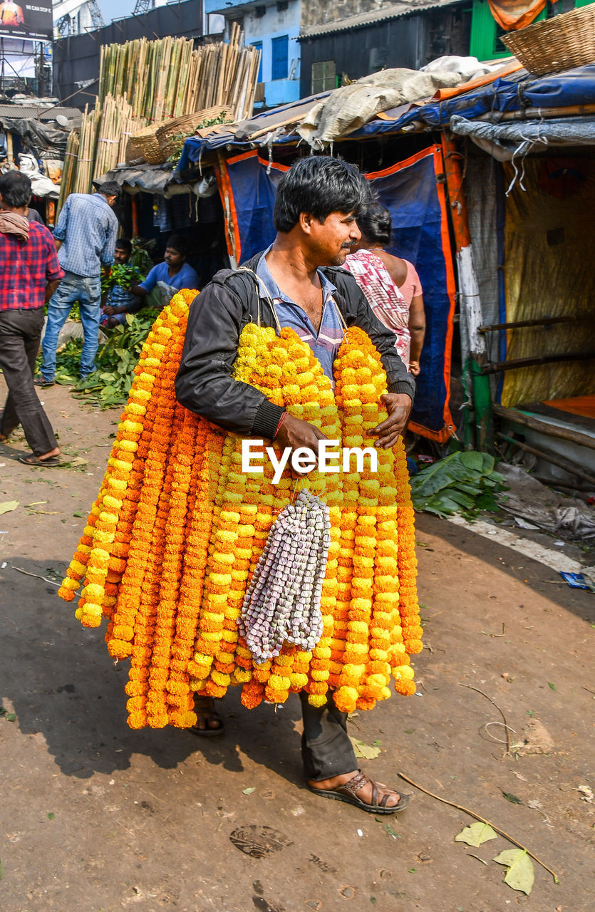 MAN WITH UMBRELLA FOR SALE IN MARKET