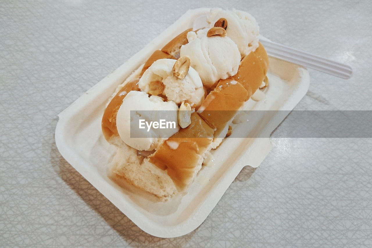 HIGH ANGLE VIEW OF ICE CREAM ON WOODEN TABLE