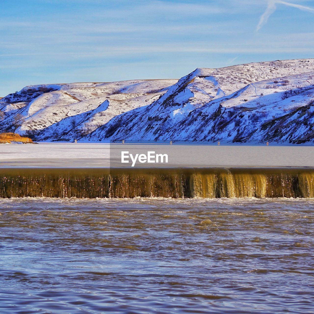 Scenic view of snowcapped mountains by sea against sky