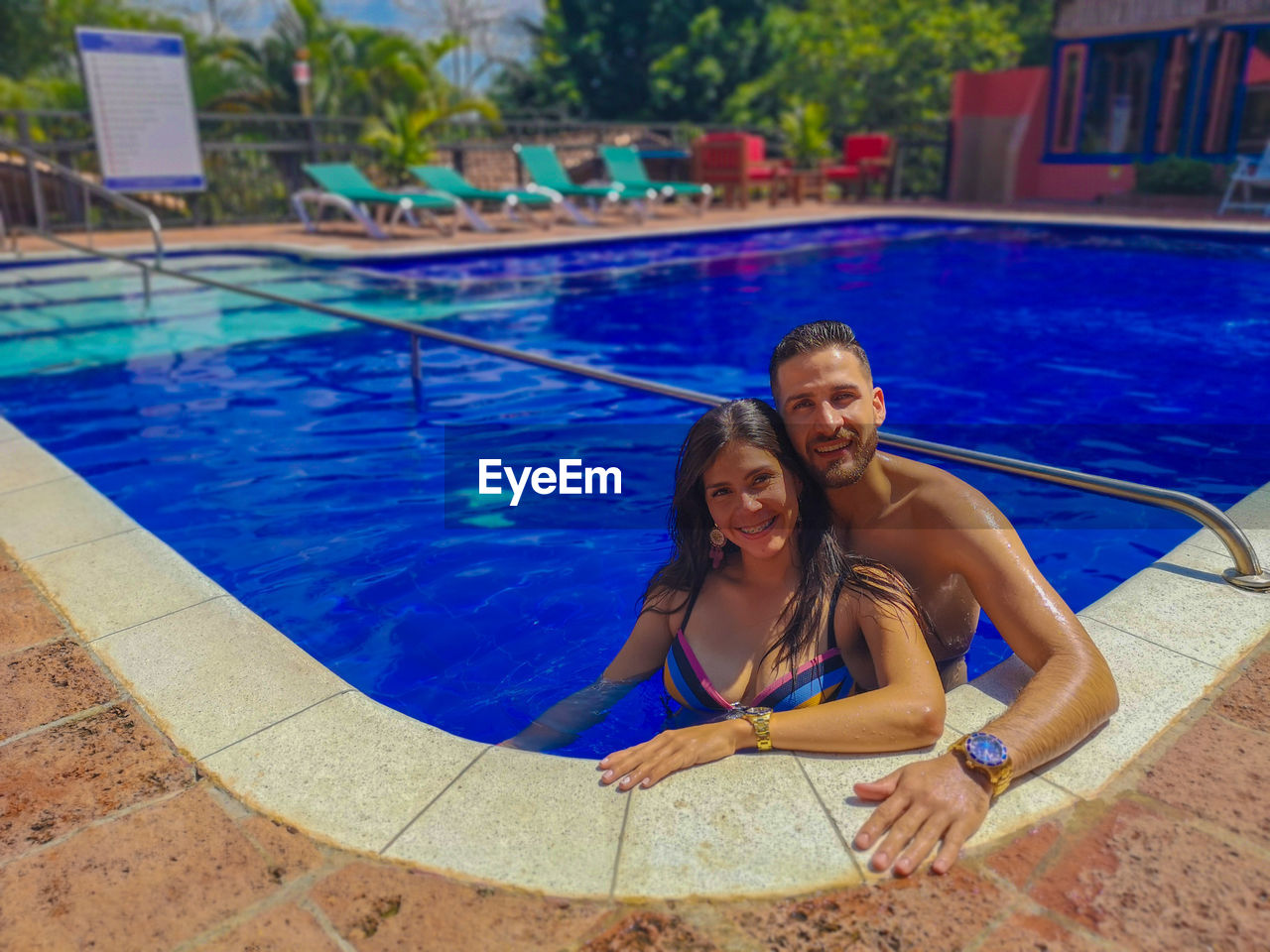 Portrait of smiling young couple in swimming pool