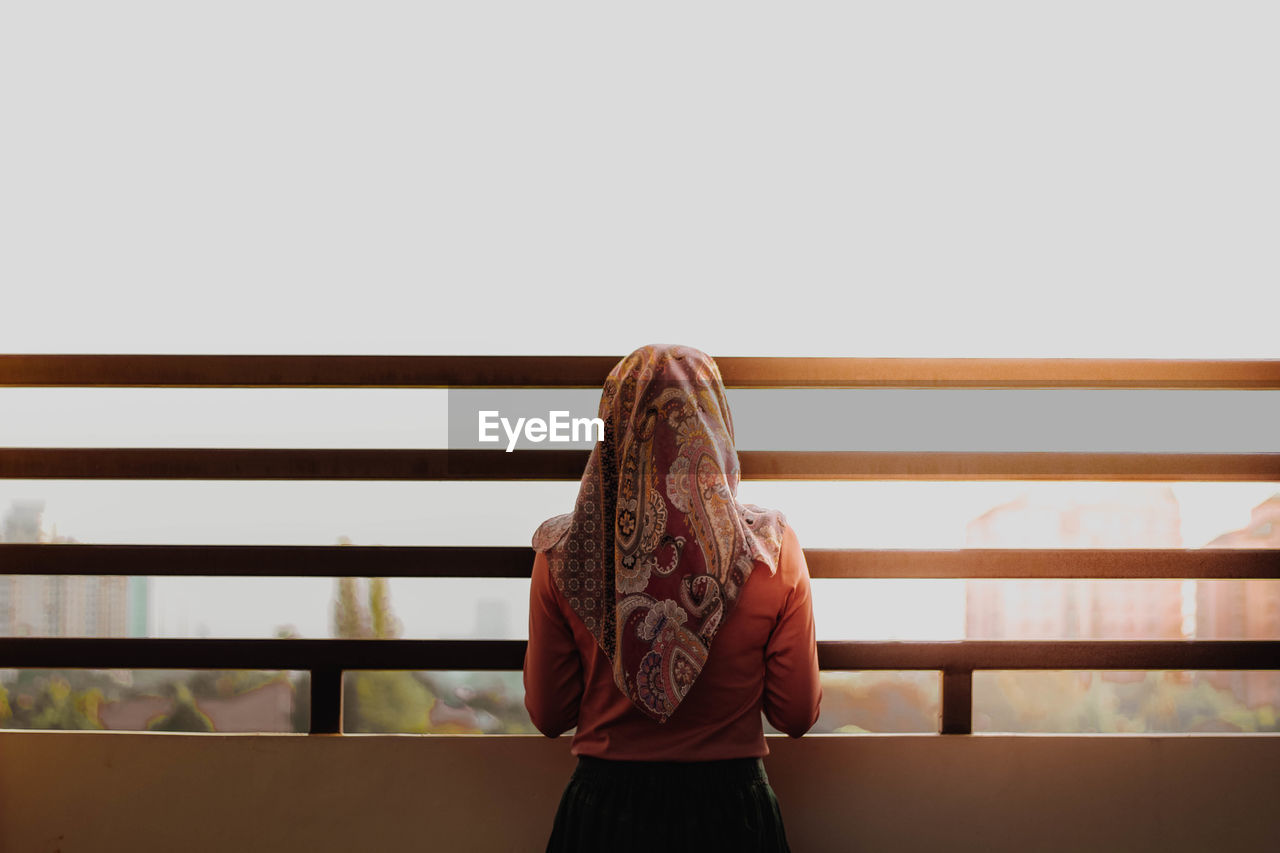 Woman standing against railing