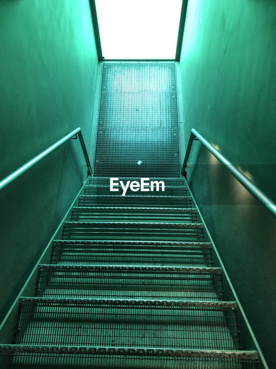 LOW ANGLE VIEW OF ESCALATOR IN ILLUMINATED WALL