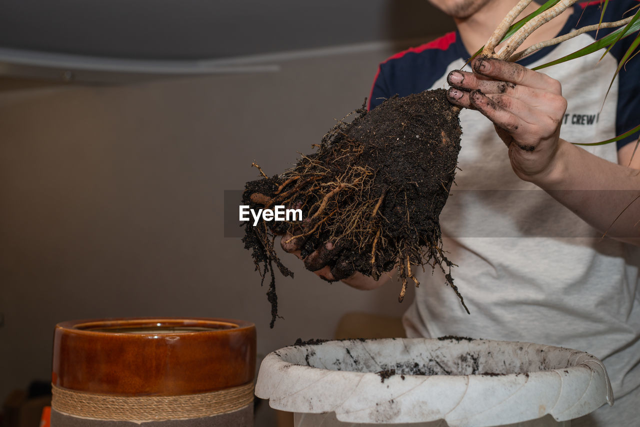 one person, adult, art, holding, food and drink, occupation, hand, food, indoors, midsection, men, clothing, business, working