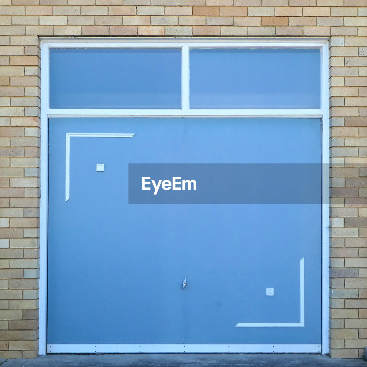 CLOSE-UP OF BLUE WALL WITH WINDOWS ON BUILDING