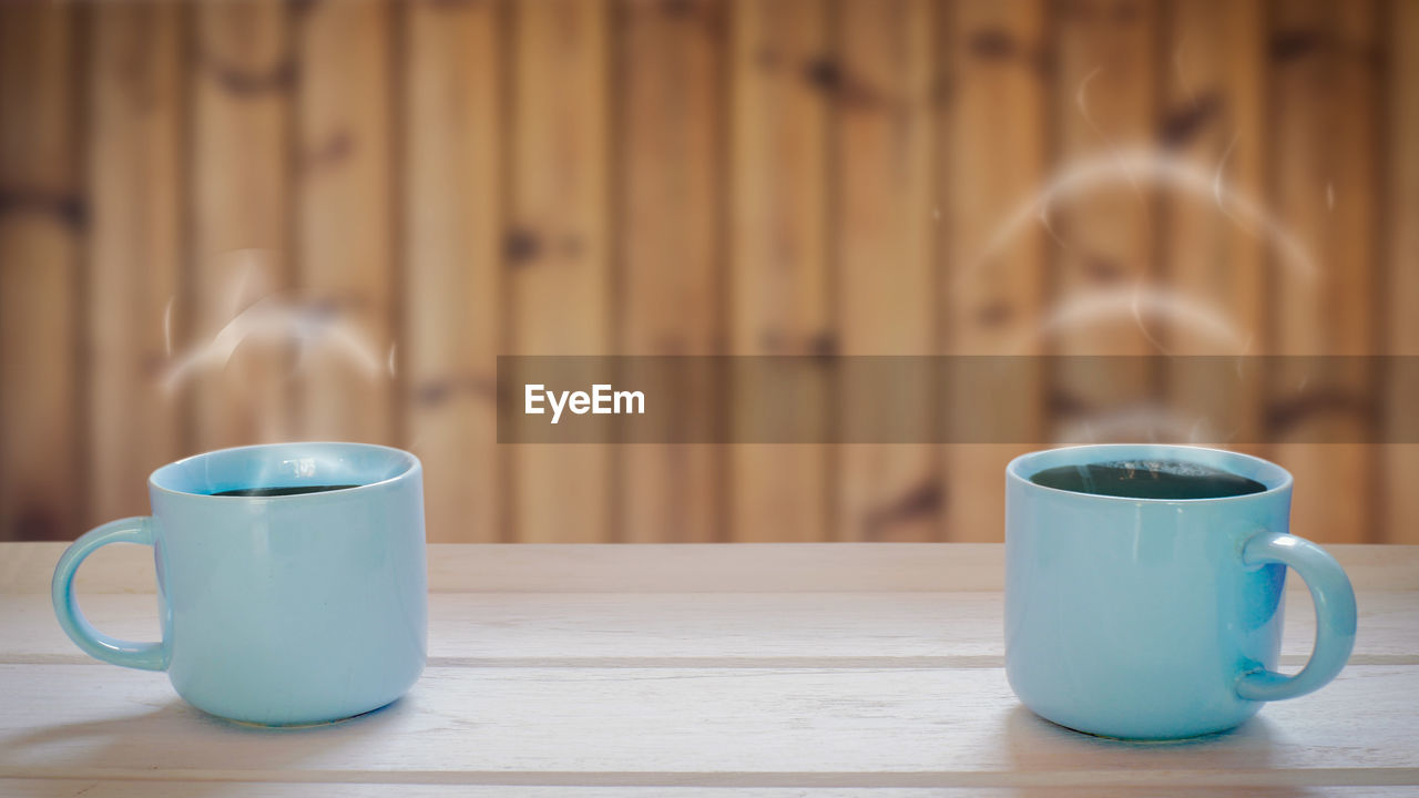 Two coffee cup concepts on a wooden table smoke is volume icon.