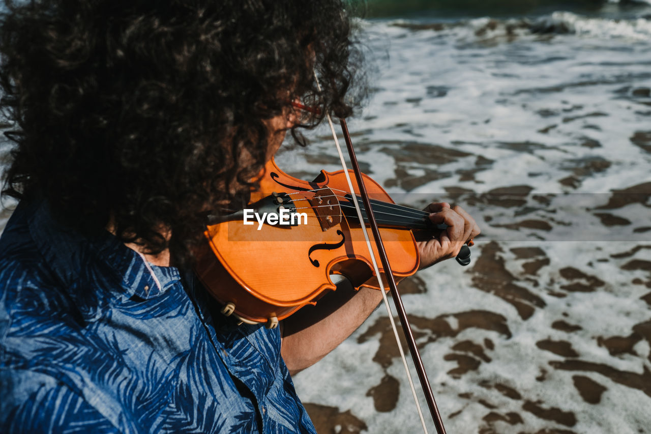 Man playing violin at beach