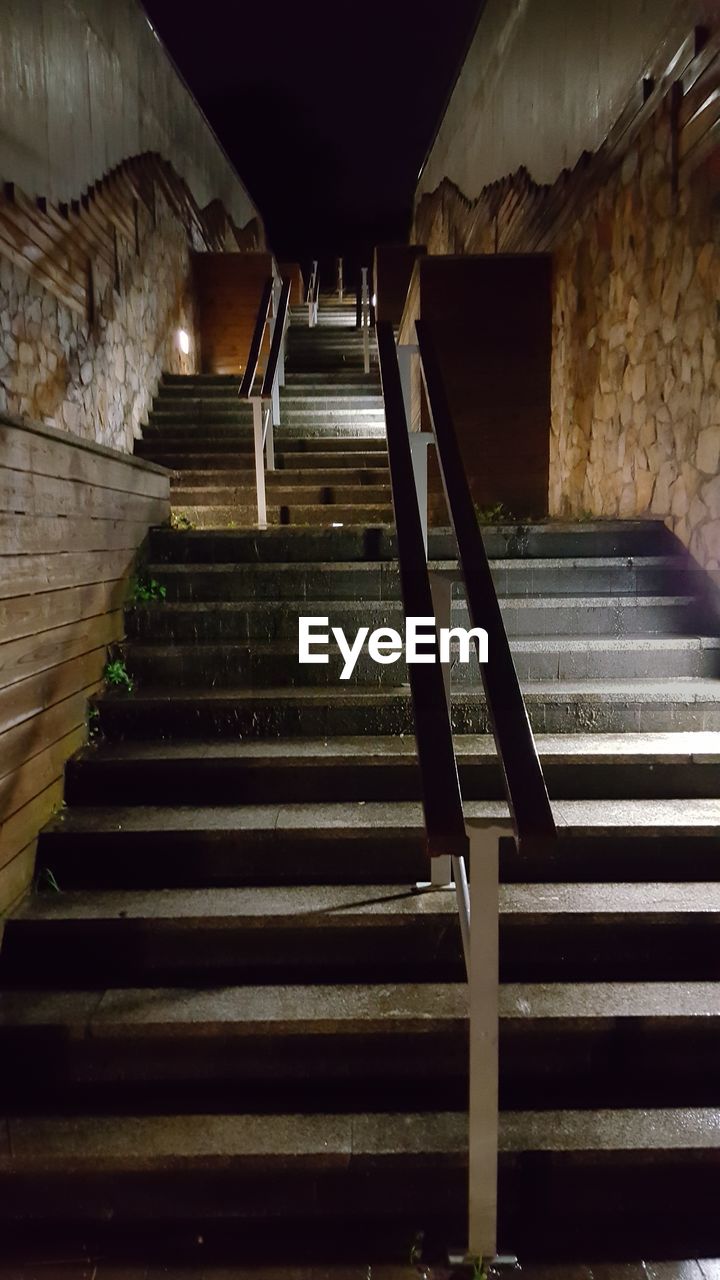 LOW ANGLE VIEW OF STEPS AND ILLUMINATED STAIRCASE AT NIGHT