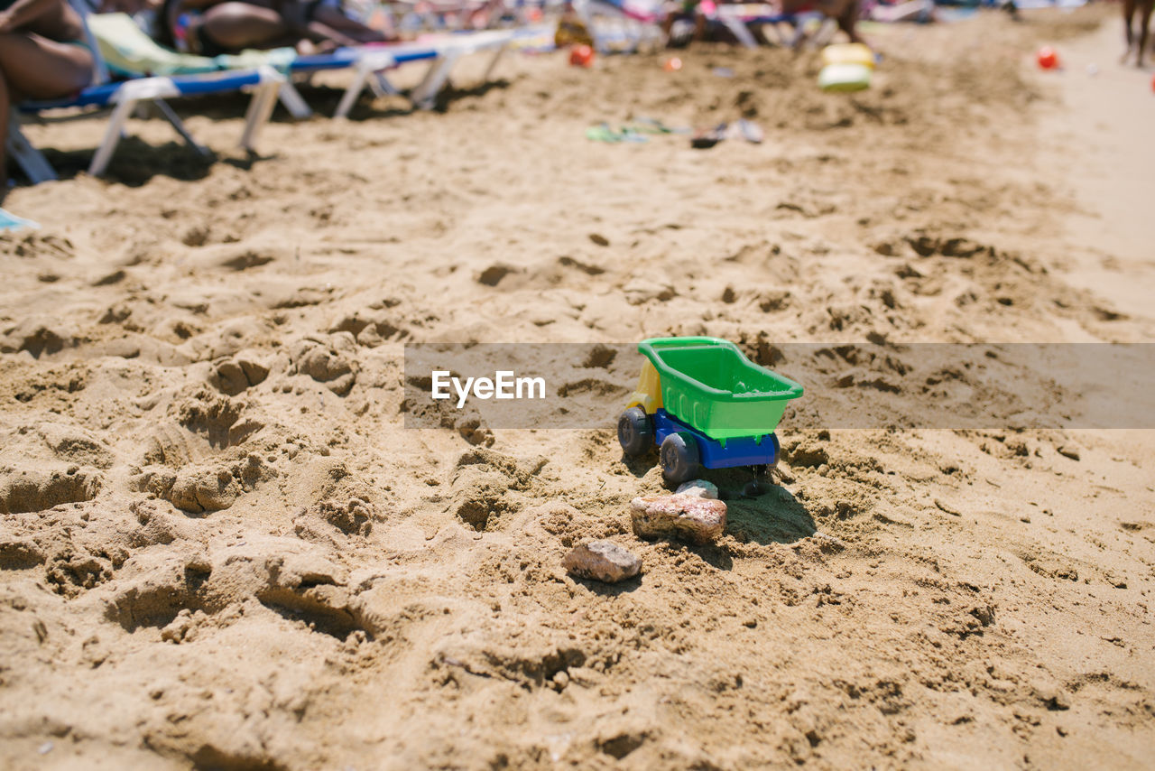 HIGH ANGLE VIEW OF TOY IN SAND