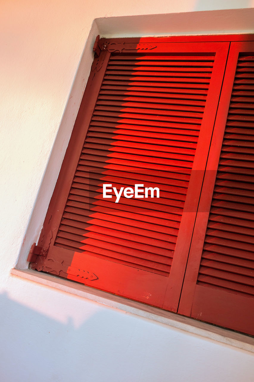 CLOSE-UP OF WINDOW ON RED BLINDS