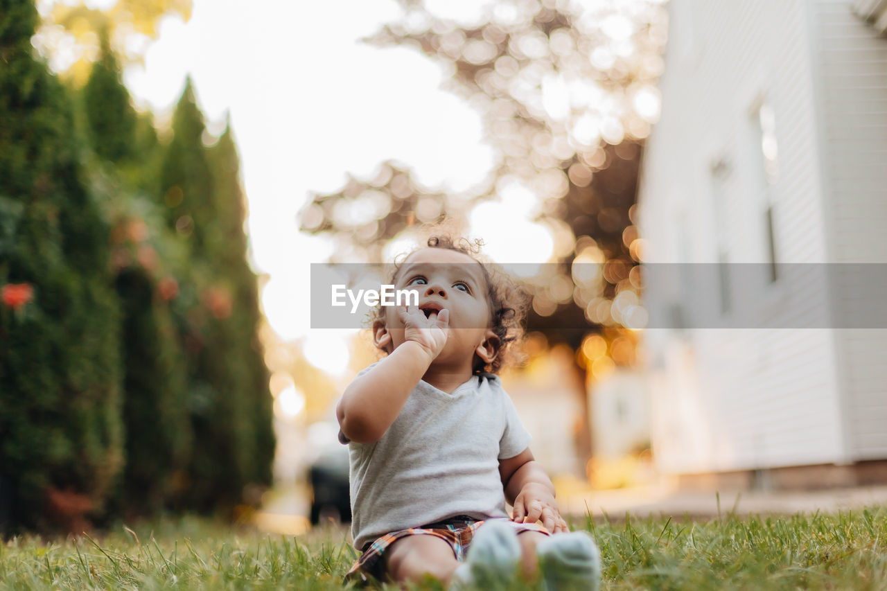 Portrait of diverse mixed race baby boy at home in backyard with golden hour sunset