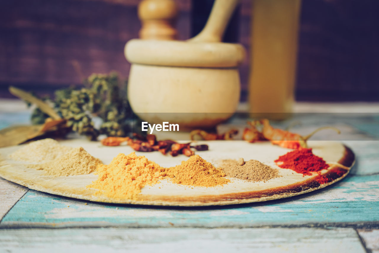 Spices by mortar and pestle on table