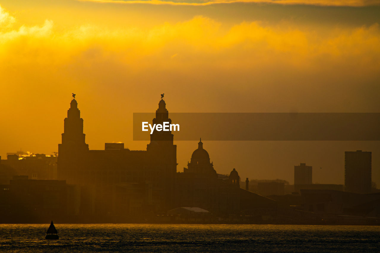 Silhouette buildings against sky during sunset