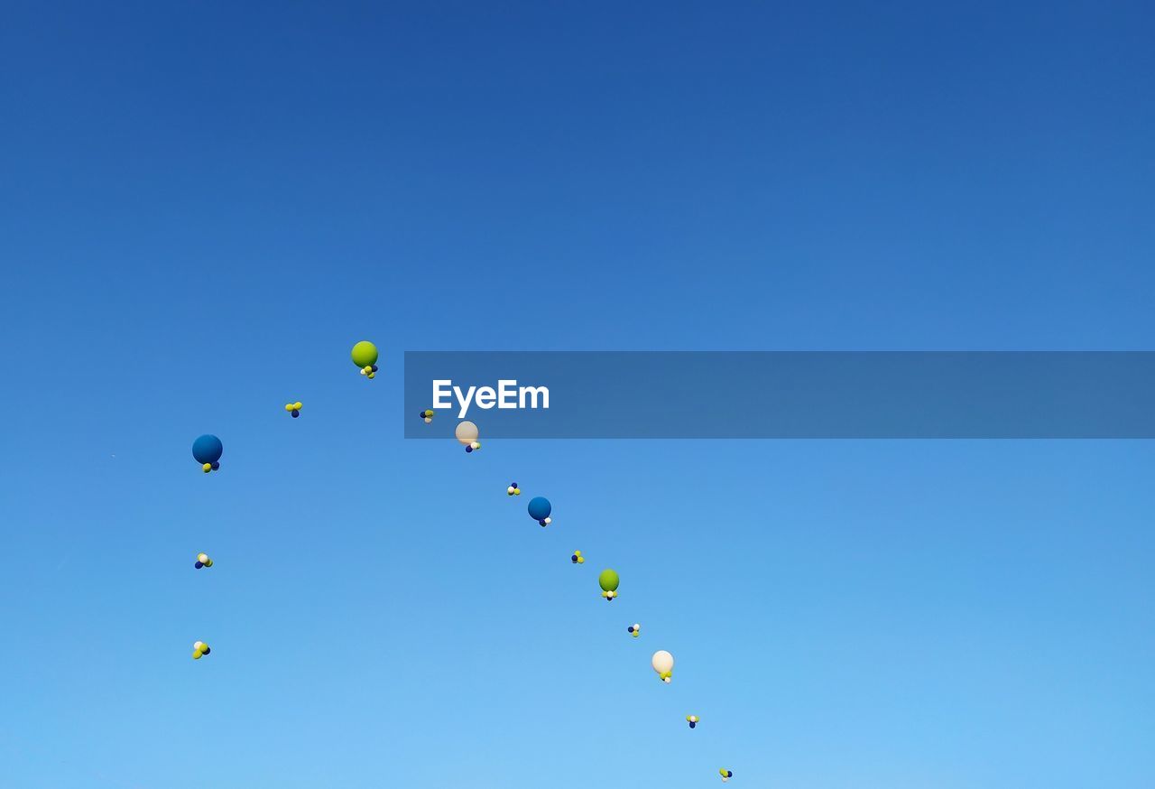 LOW ANGLE VIEW OF BALLOONS IN SKY