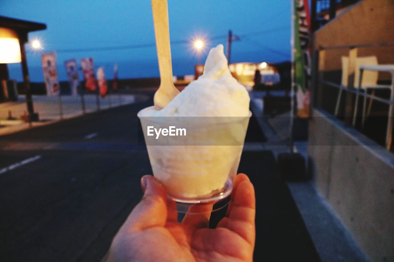 CLOSE-UP OF HAND HOLDING ICE CREAM