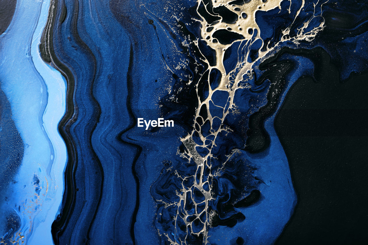 Dark blue waves in abstract ocean and golden inclusion. liquid acrylic artwork. marble effect 