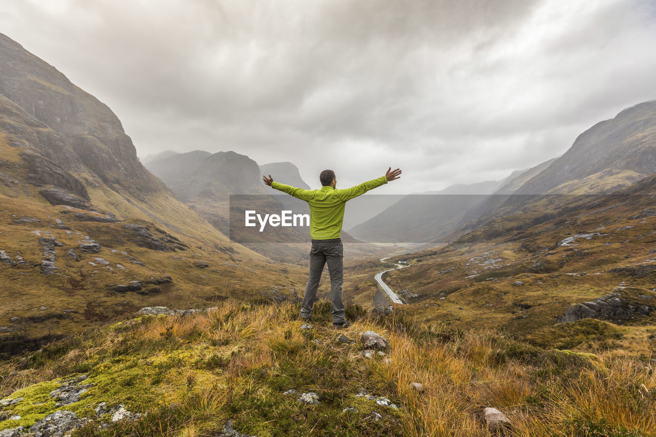 Uk, scotland, man in the scottish highlands near glencoe with a view on the three sisters