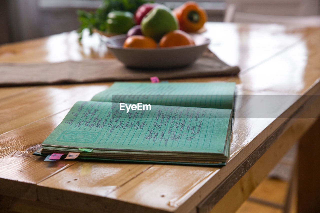 Spices and old recipe book on wooden background on kitchen.