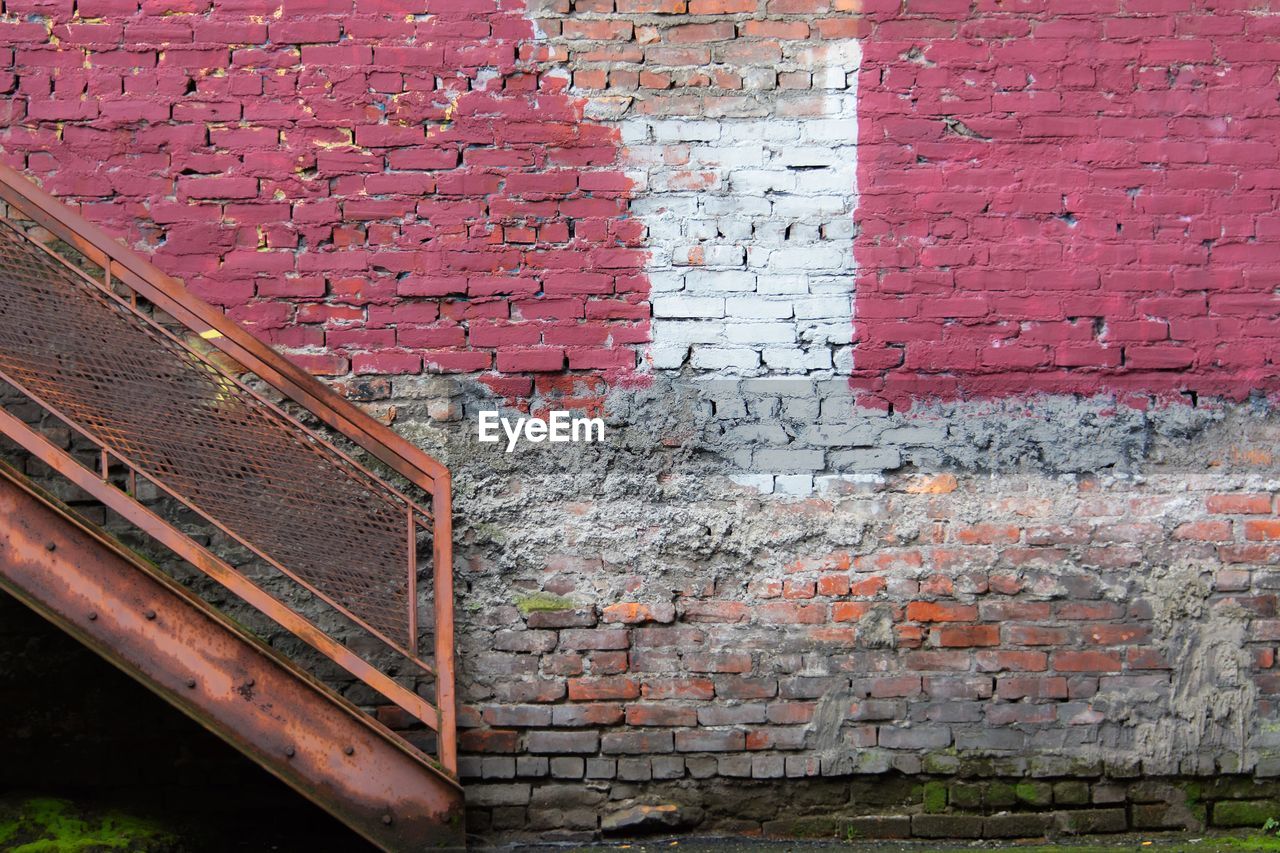 FULL FRAME SHOT OF BRICK WALL WITH BUILDING